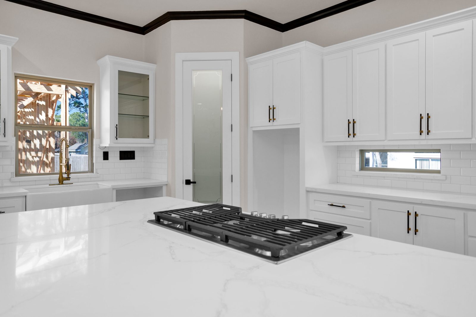 Gas cooktop on quartz island with custom cabinetry