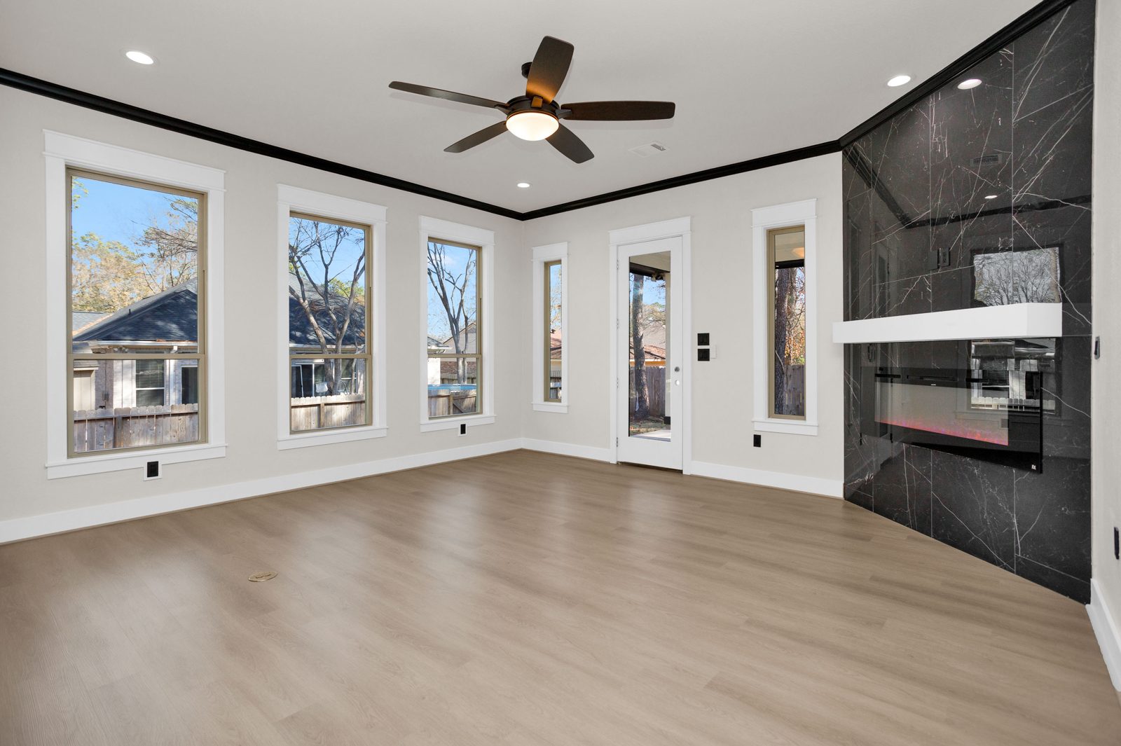Open-concept living room with black marble fireplace wall
