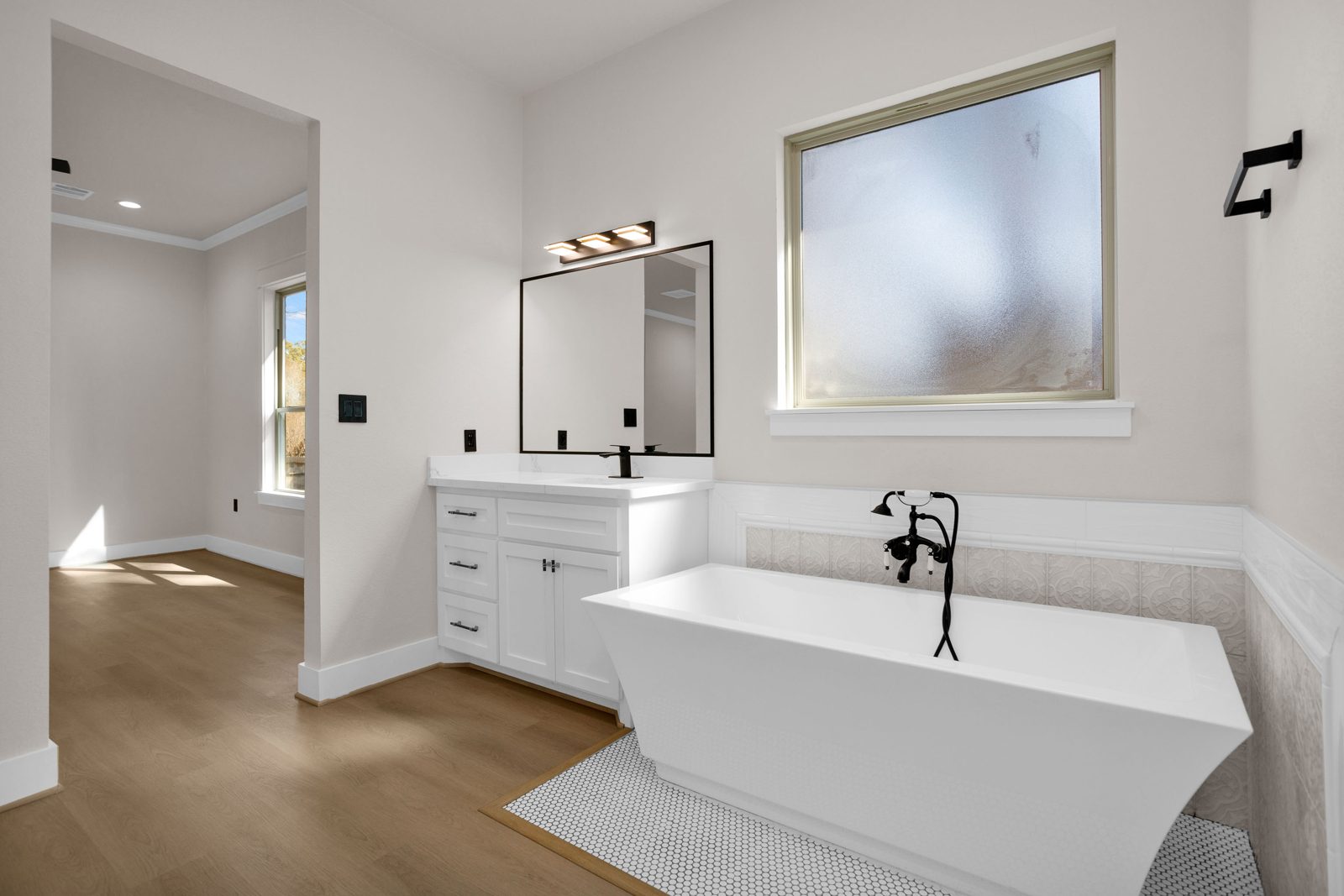 Primary bath with freestanding soaker tub and matte black fixtures