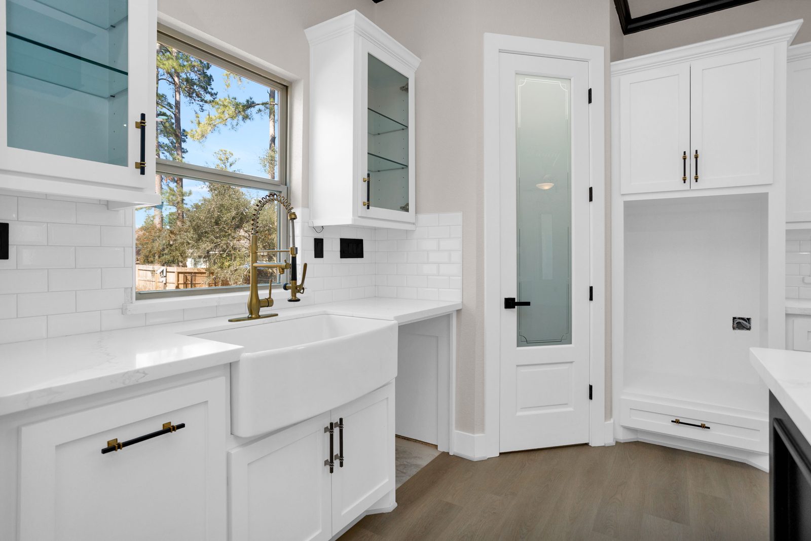 Farmhouse sink with subway tile backsplash and brass fixtures